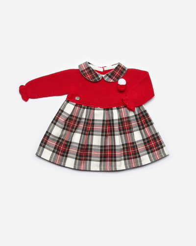 Juliana branded girls red knitted dress with small red and white pom pom detail to the front and tartan print fabric around the bottom. The collars on the dress are also in a tartan print. Button opening on the back. Available in sizes 3m up to 4yr.