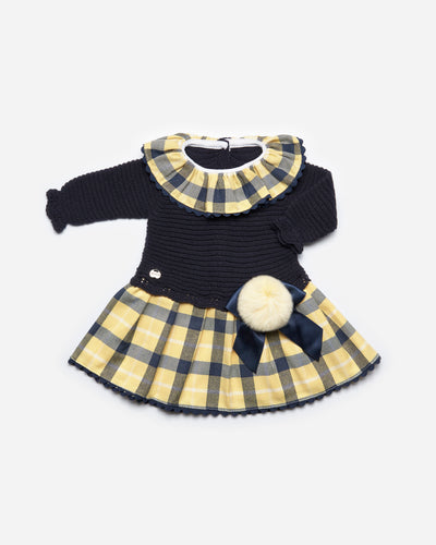 Girls navy blue & yellow knitted long sleeve dress by Juliana. This stunning dress has a yellow tartan print frill around the neck, and matching tartan print across the bottom. Large box with navy ribbon on the side of the waist band. Button opening on the back. Available in sizes 3m up 4yr.